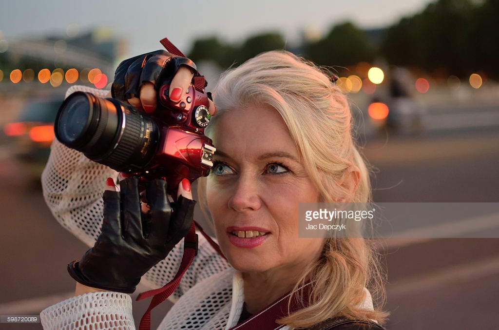 The light in her eye reflects the light in the world. Elegant woman with red camera taking photo. Photo shoot for Getty Images. Ali Lochhead shot by Jac Depczyk in Paris. https://www.gettyimages.com/license/598720089