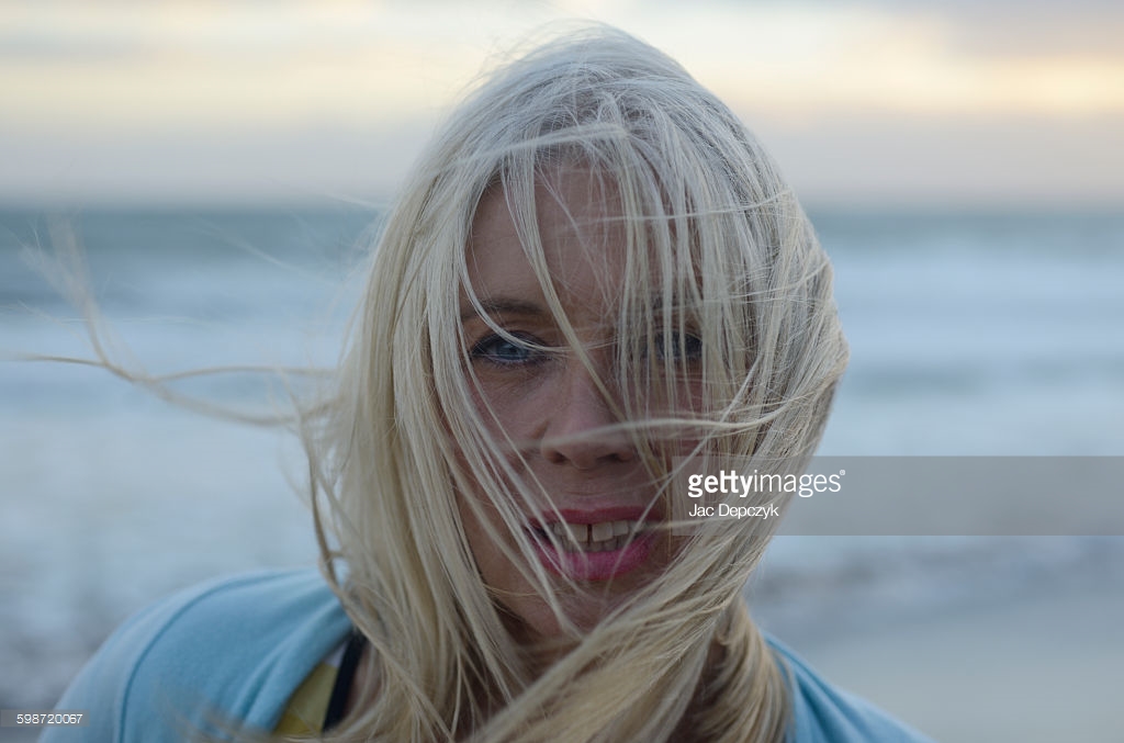 Mature woman with blonde hair over face at beach. The beautiful beaches of Andalusia. Photo shoot for Getty Images - Ali Lochhead shot by Jac Depczyk. https://www.gettyimages.com/license/598720067